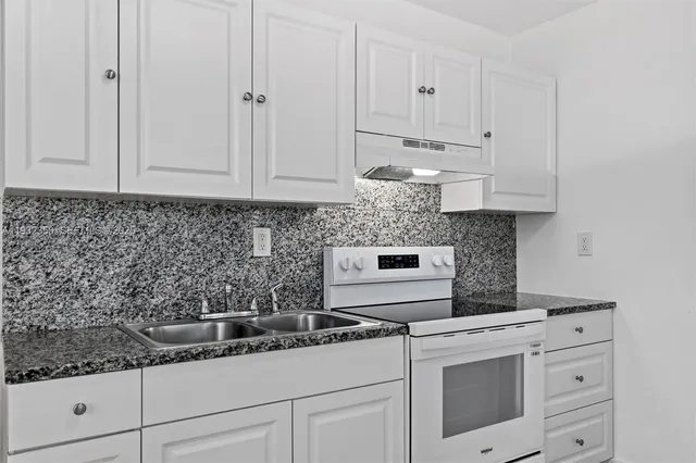 a kitchen with white cabinets and white appliances