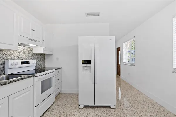 a kitchen with white cabinets and white appliances