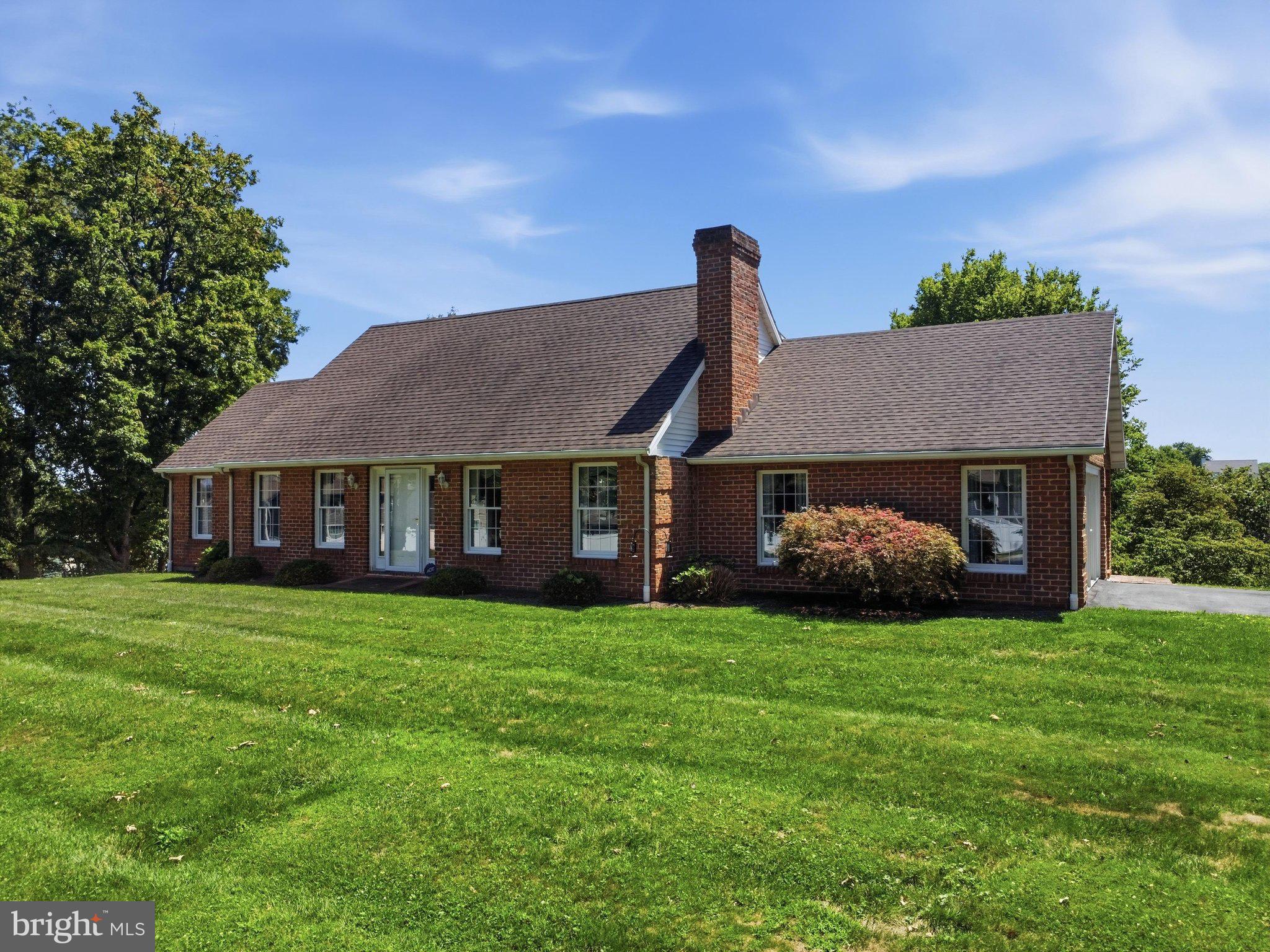 Charming brick home on lush green grounds.
