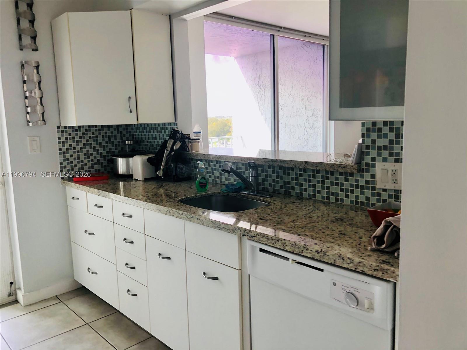 650 Northeast 64th Street, Unit G609 Miami, FL 33138 - Photo 13 of 15 a bathroom with a granite countertop sink and a mirror
