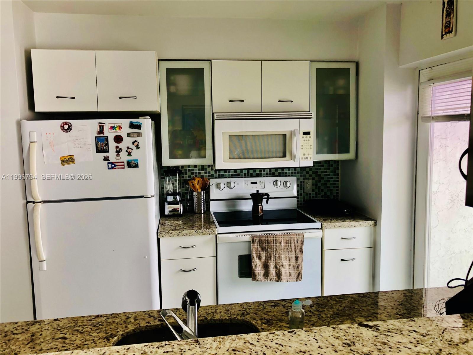 650 Northeast 64th Street, Unit G609 Miami, FL 33138 - Photo 10 of 15 a kitchen with stainless steel appliances granite countertop a refrigerator and a stove