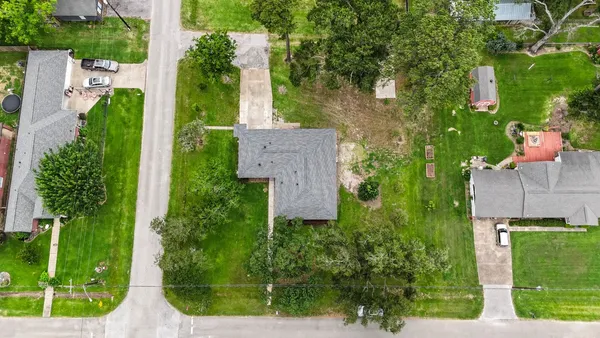 an aerial view of a house with a garden and trees