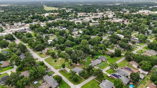 an aerial view of residential houses with outdoor space and trees