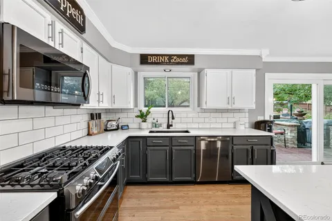 a kitchen with stainless steel appliances a stove sink microwave and cabinets