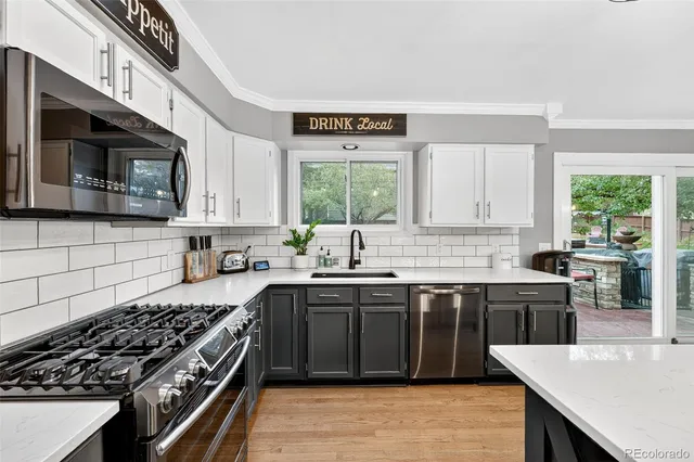a kitchen with stainless steel appliances a stove sink microwave and cabinets