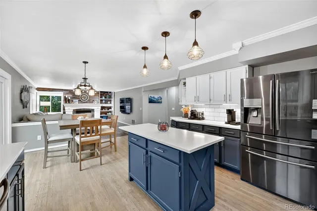 a kitchen with a stove center island cabinets and wooden floor