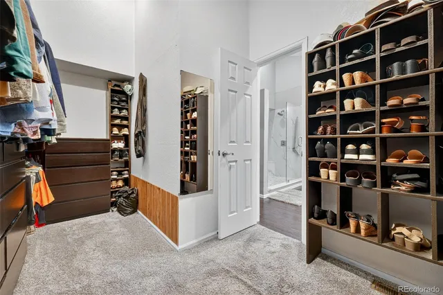 a view of walk in closet with clothes and shoes