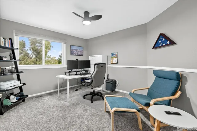 a view of a workspace with furniture and a window