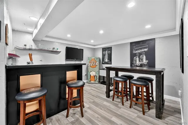 a living room with furniture a flat screen tv and kitchen view