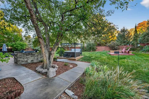 a front view of a house with a garden and tree
