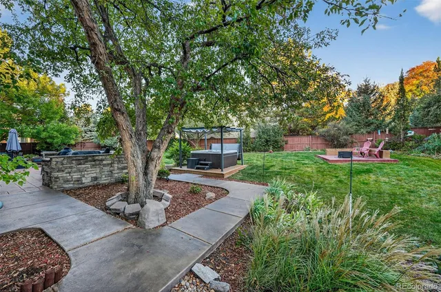 a front view of a house with a garden and tree