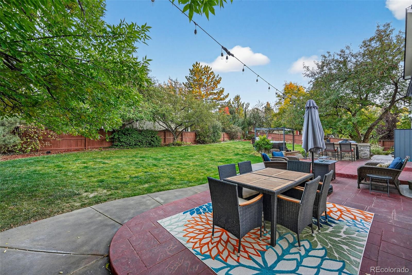 9910 Ashleigh Way Highlands Ranch, CO 80126 - Photo 37 of 49 a view of a patio with table and chairs potted plants and a large tree