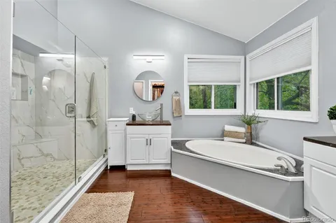 a bathroom with a tub a sink and a large mirror