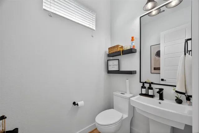 a bathroom with a toilet sink and mirror
