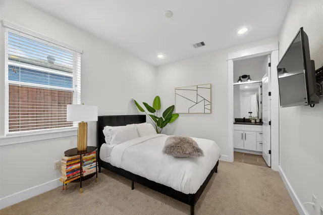 a bedroom with a bed a flat screen tv and a couch