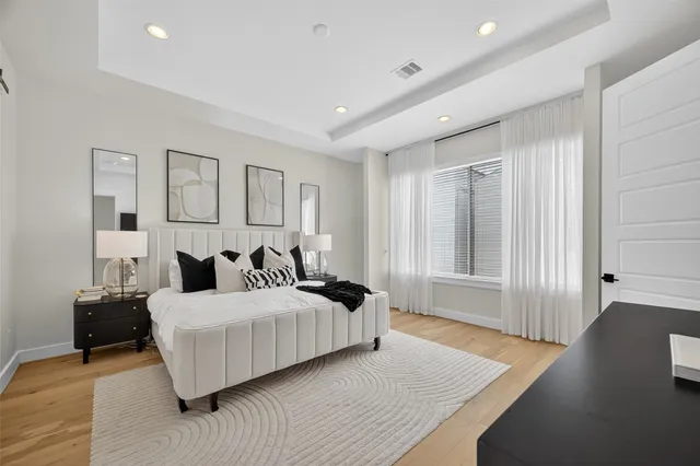 a bedroom with a bed and a large window