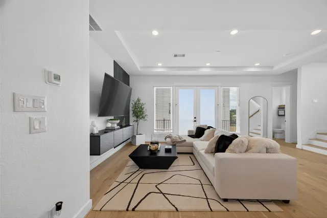 a living room with furniture a flat screen tv and a window