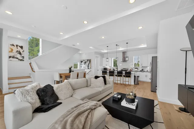 a living room with furniture and a view of kitchen