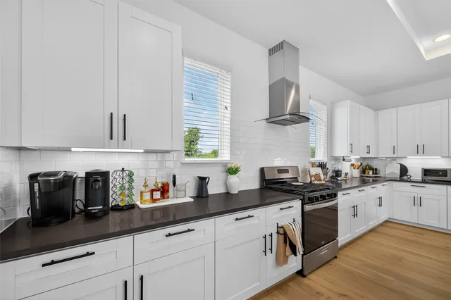 a kitchen with granite countertop a sink a stove and cabinets
