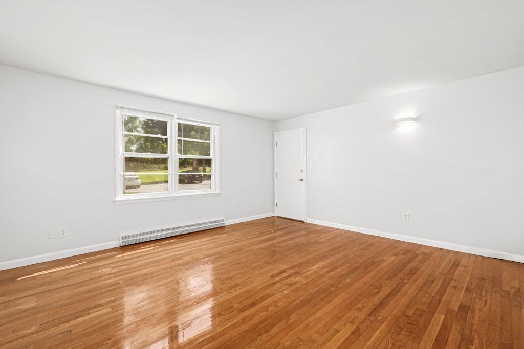 22 Southwest Cutoff, Unit D Northborough, MA 01532 - Photo 3 of 12 an empty room with wooden floor and windows