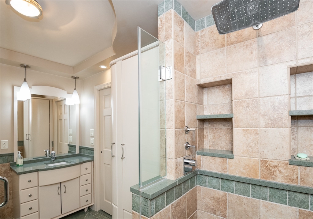 25 Ellen Road Stoneham, MA 02180 - Photo 33 of 41 a bathroom with a granite countertop sink a mirror and a shower