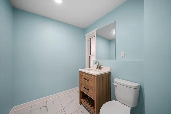 a bathroom with a toilet a sink and mirror