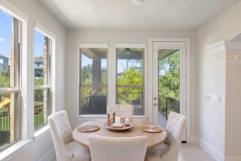 a large white kitchen with a large window and stainless steel appliances