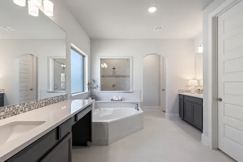 a spacious bedroom with a bed and a flat screen tv