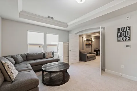 a view of a hallway with livingroom with furniture and windows