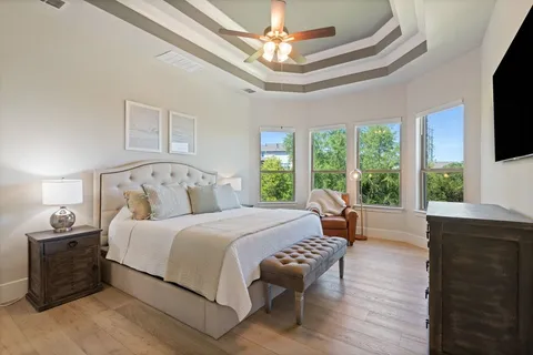 a bedroom with a large bed and a flat tv screen on dresser