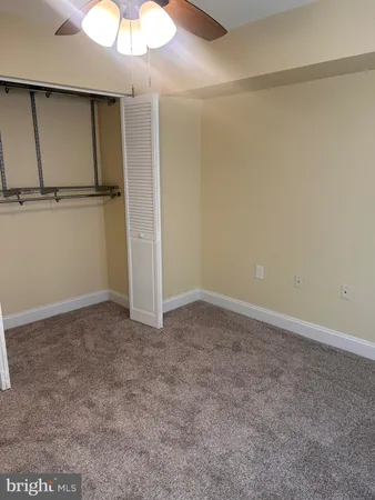 a view of an empty room and a kitchen