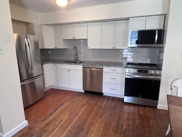 a kitchen with a stove a refrigerator and a microwave