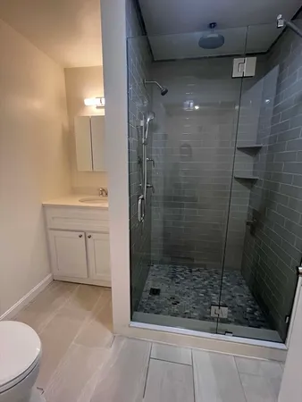 a bathroom with a shower a toilet and sink