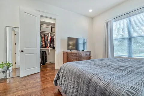 a large bedroom with a bed and a flat screen tv
