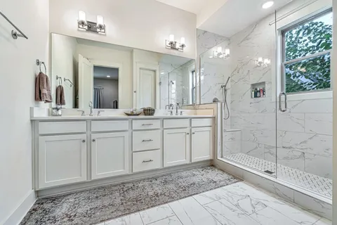 a spacious bathroom with a shower sink and mirror