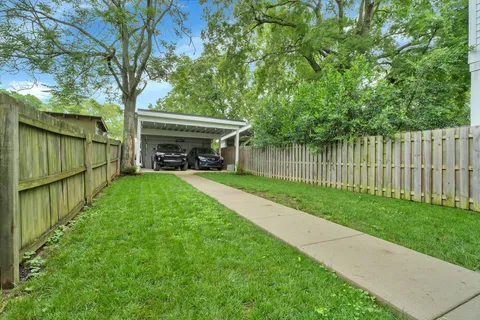 a view of a house with backyard and a tree