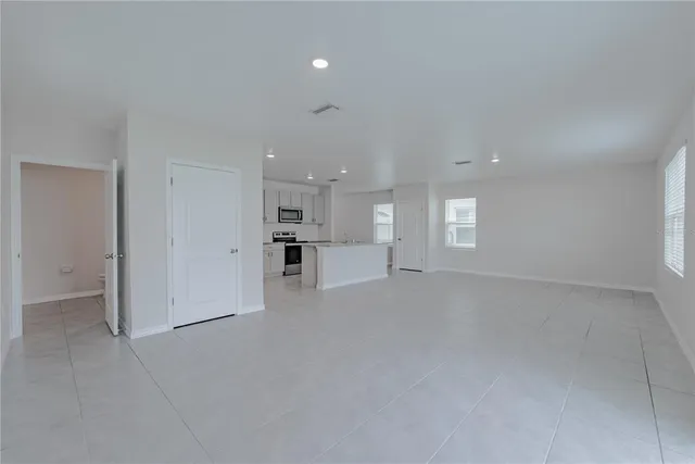 a kitchen with stainless steel appliances a sink a stove a refrigerator cabinets and a window