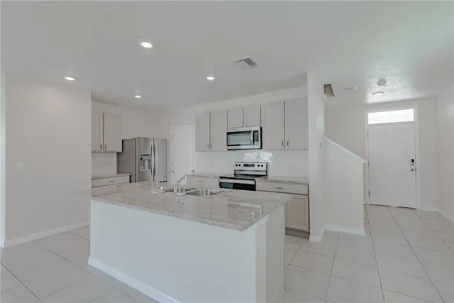 a kitchen with stainless steel appliances granite countertop a sink stove and microwave