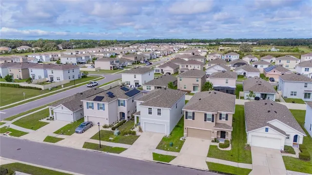 an aerial view of residential houses with outdoor space and parking