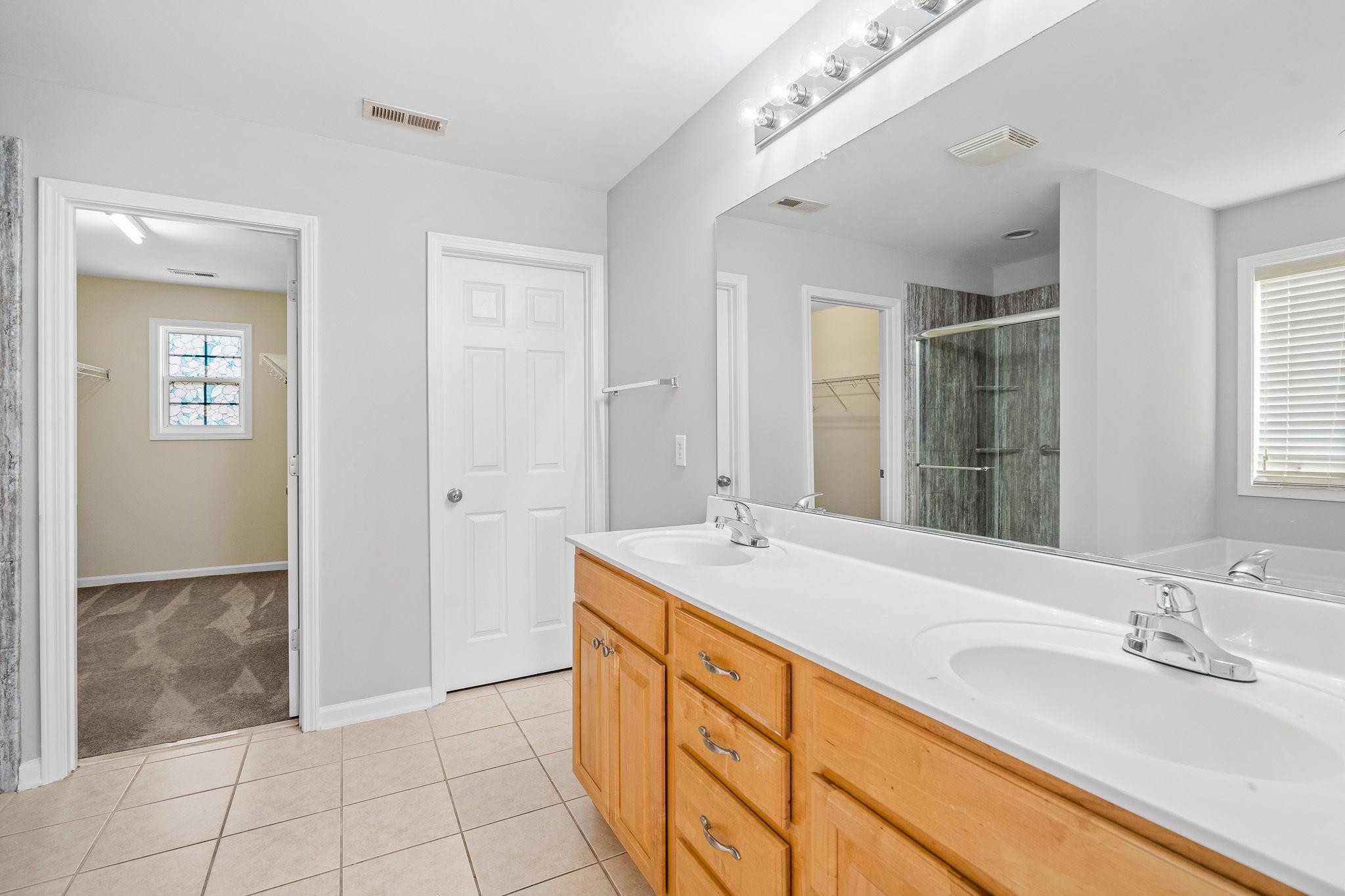 113 Whitney Lane Durham, NC 27713 - Photo 25 of 34 a spacious bathroom with a granite countertop sink and a mirror