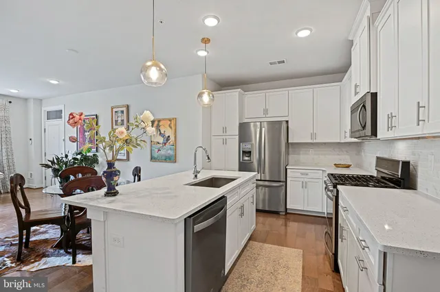 a kitchen that has a lot of cabinets a sink and appliances in it