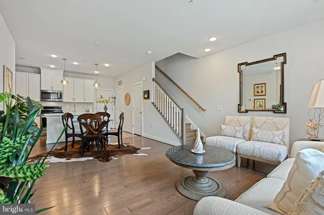 a living room with furniture kitchen view and a potted plant