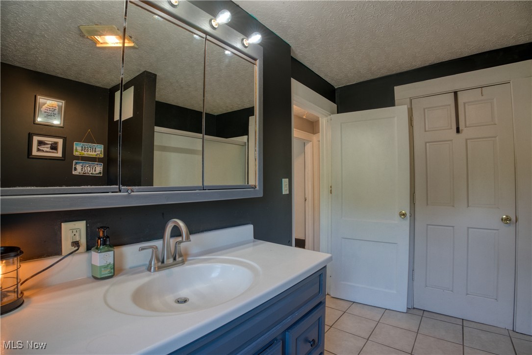 2161 Canton Road Akron, OH 44312 - Photo 27 of 33 Bathroom with vanity, tile patterned floors, and a textured ceiling