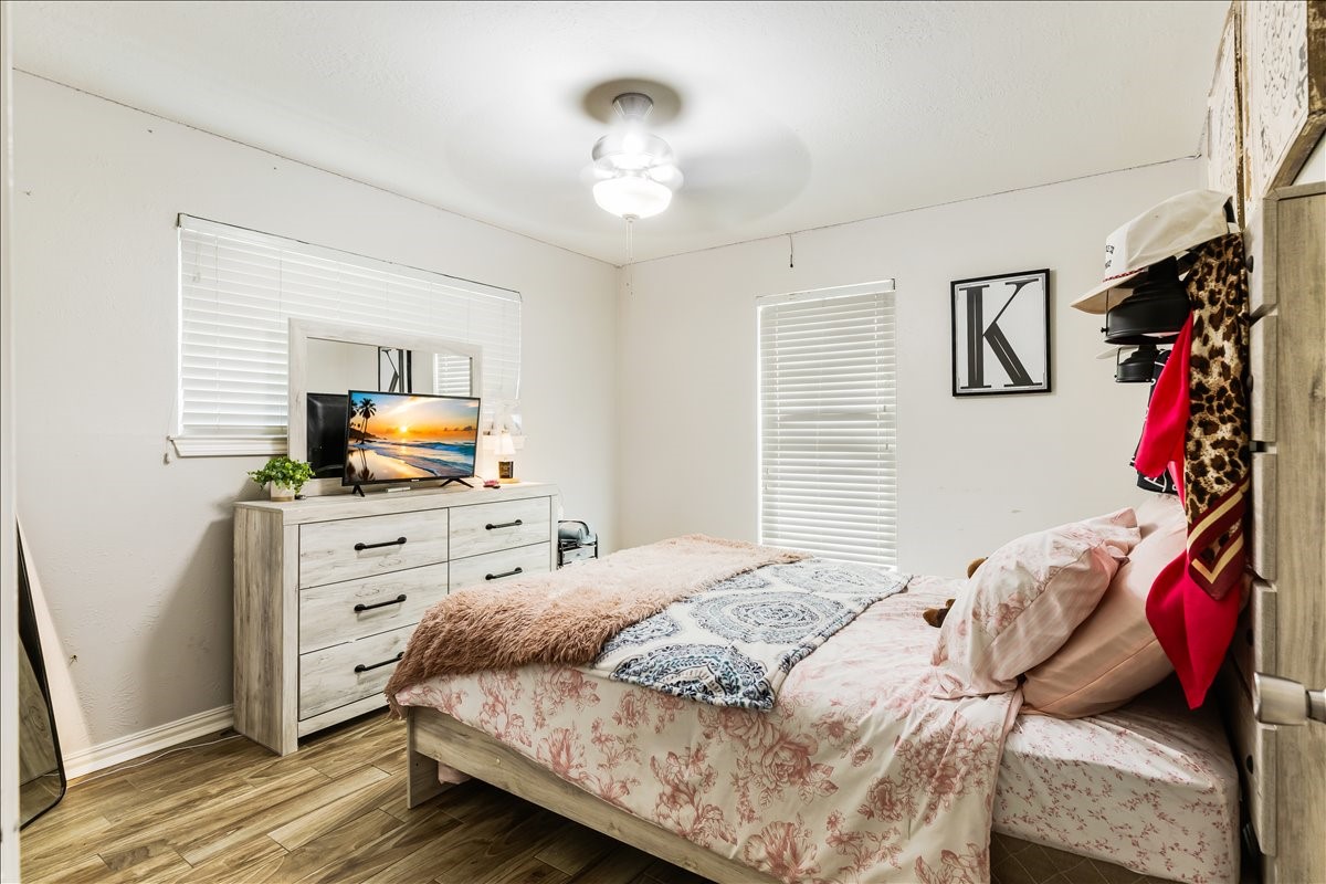 3809 Wingtail Way Pearland, TX 77584 - Photo 18 of 29 a bedroom with a bed and wooden floor