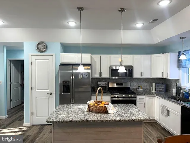 a kitchen with a refrigerator a sink and cabinets