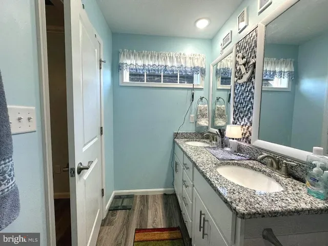 a bathroom with a granite countertop sink a mirror and a shower