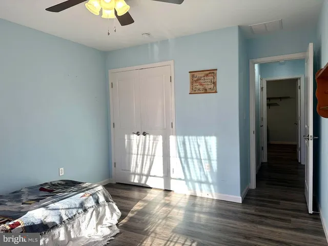 a view of a bedroom with wooden floor and windows