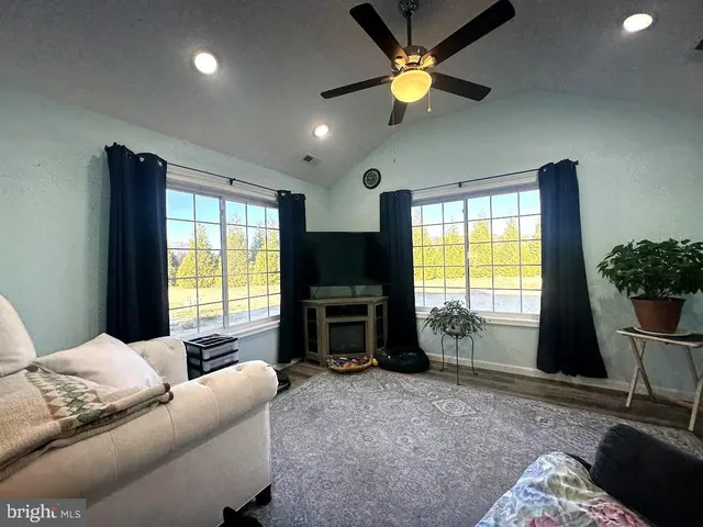 a living room with furniture a window and a flat screen tv