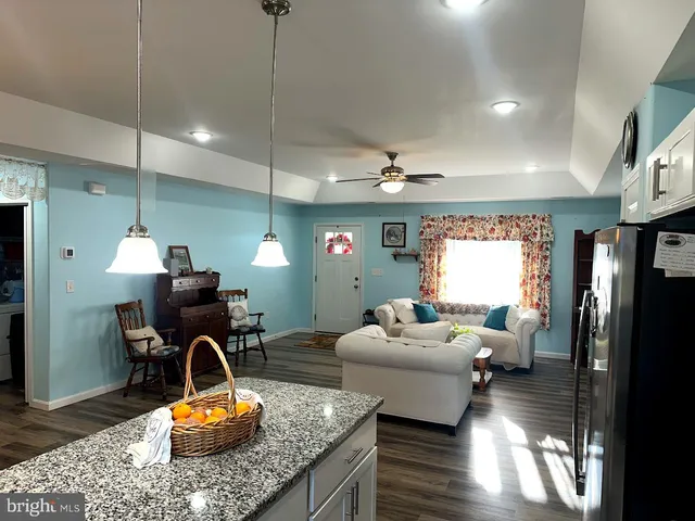 a living room with furniture a window and wooden floor