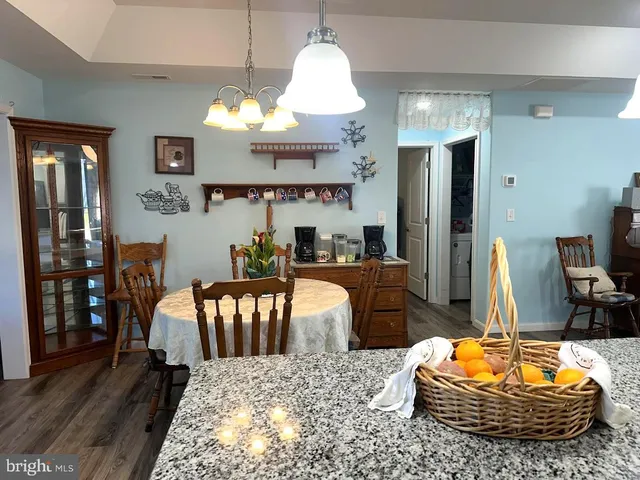 a living room with furniture a chandelier and a dining table